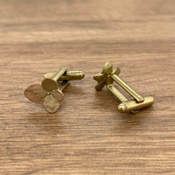 Gold cufflinks with flower design.