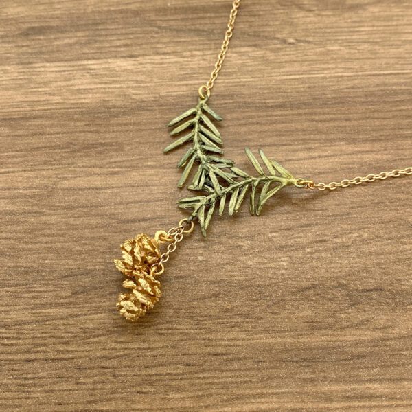 Gold necklace with pine cone and leaves.