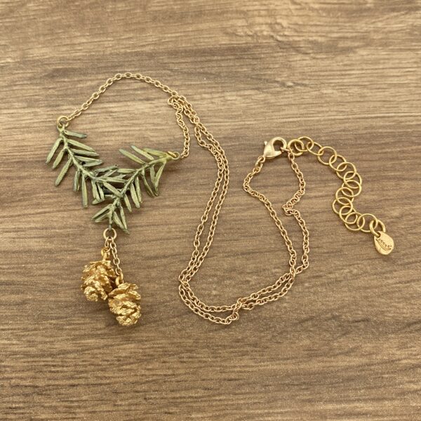 Gold necklace with pine branch and cones.