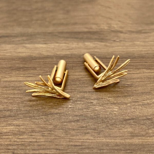 Gold cufflinks with a leaf design.