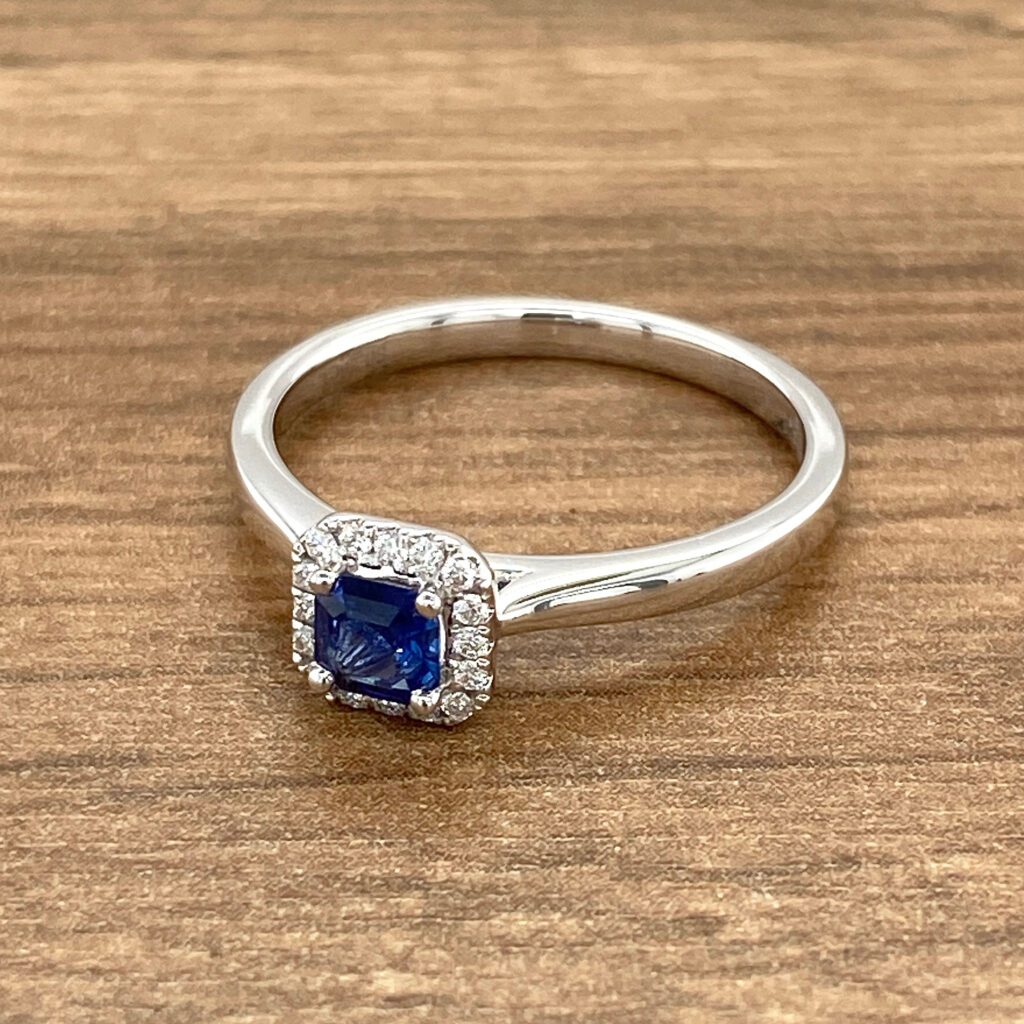 Square sapphire ring with diamond halo.