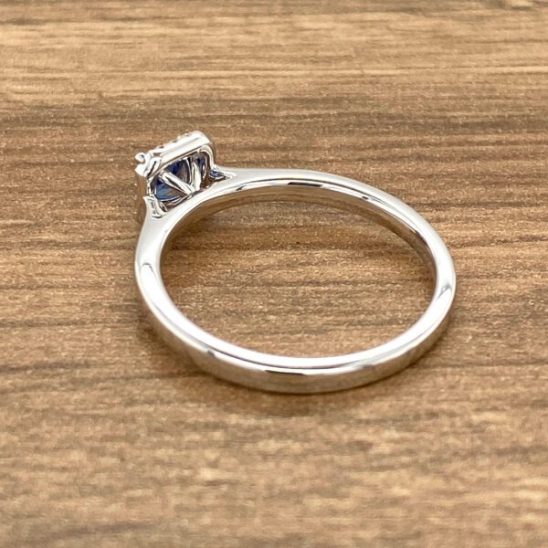 Silver ring with blue gemstone and diamonds.