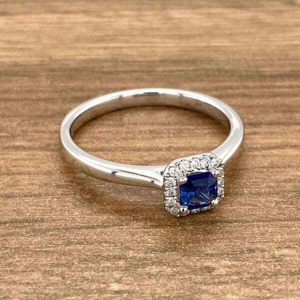 A silver ring with a blue sapphire and diamonds.