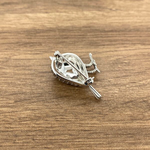 Silver bird brooch with crystal accents.