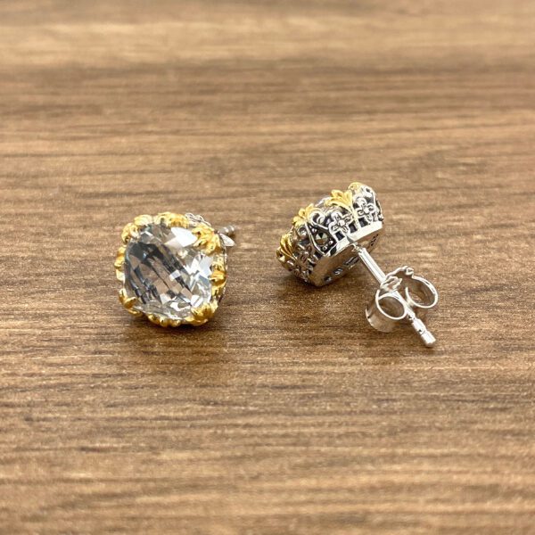 Pair of silver and gold earrings with clear stones.