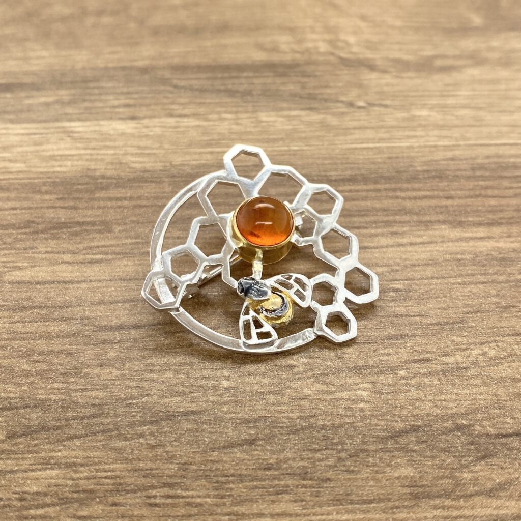 Silver bee brooch with amber stone.