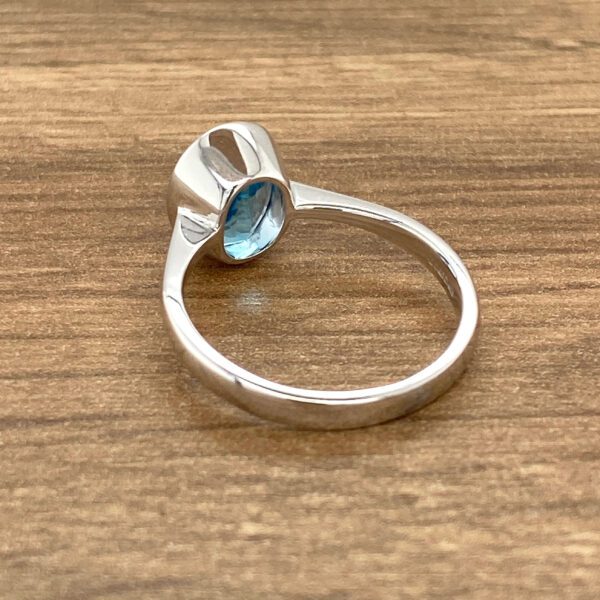 Silver ring with blue gemstone.