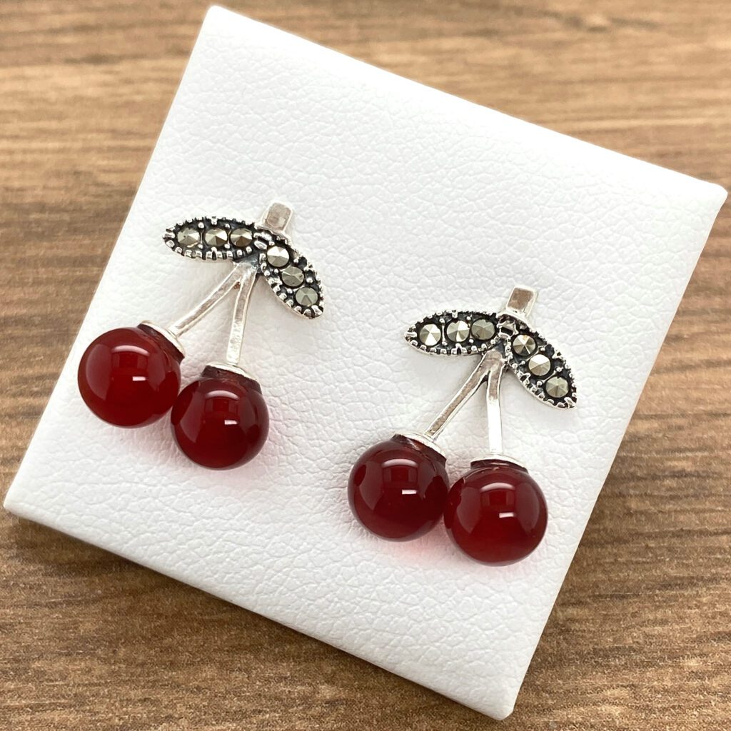 Silver cherry earrings with red stones.