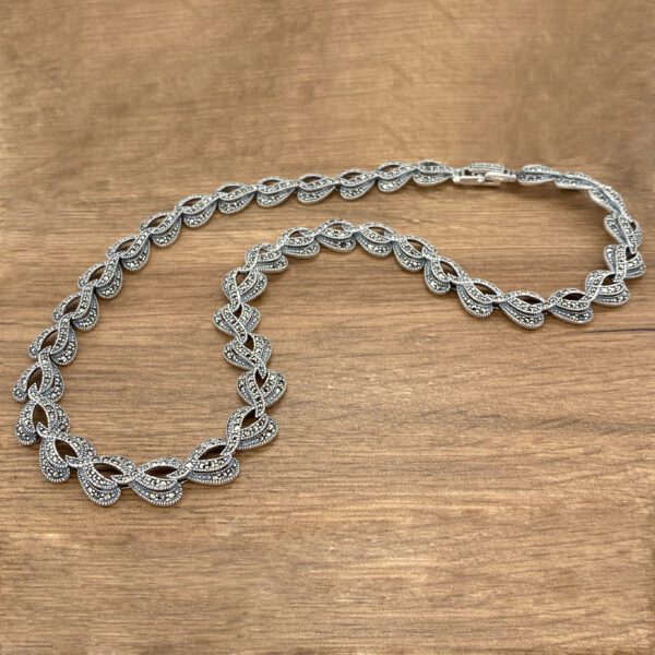Silver marcasite necklace on wood.