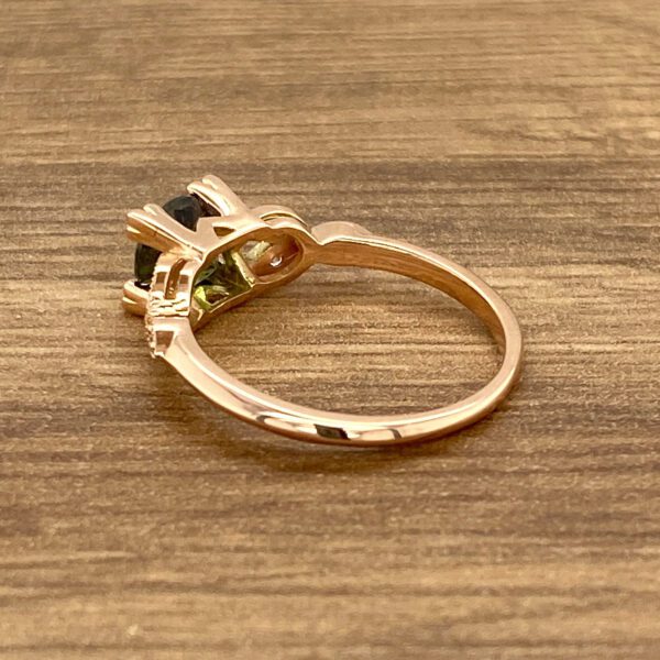 Rose gold ring with green gemstone.