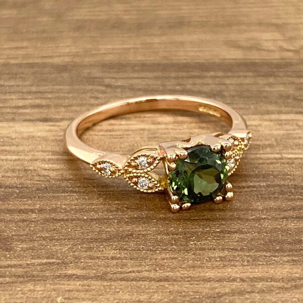 Rose gold ring with green gemstone.