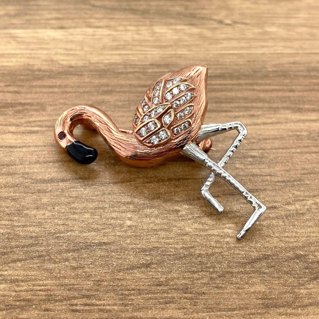 Rose gold flamingo brooch with diamonds.