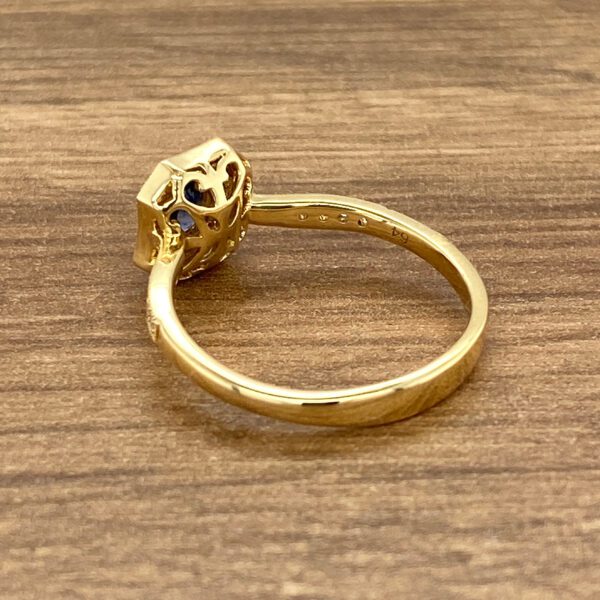 Gold ring with blue gemstone and filigree.