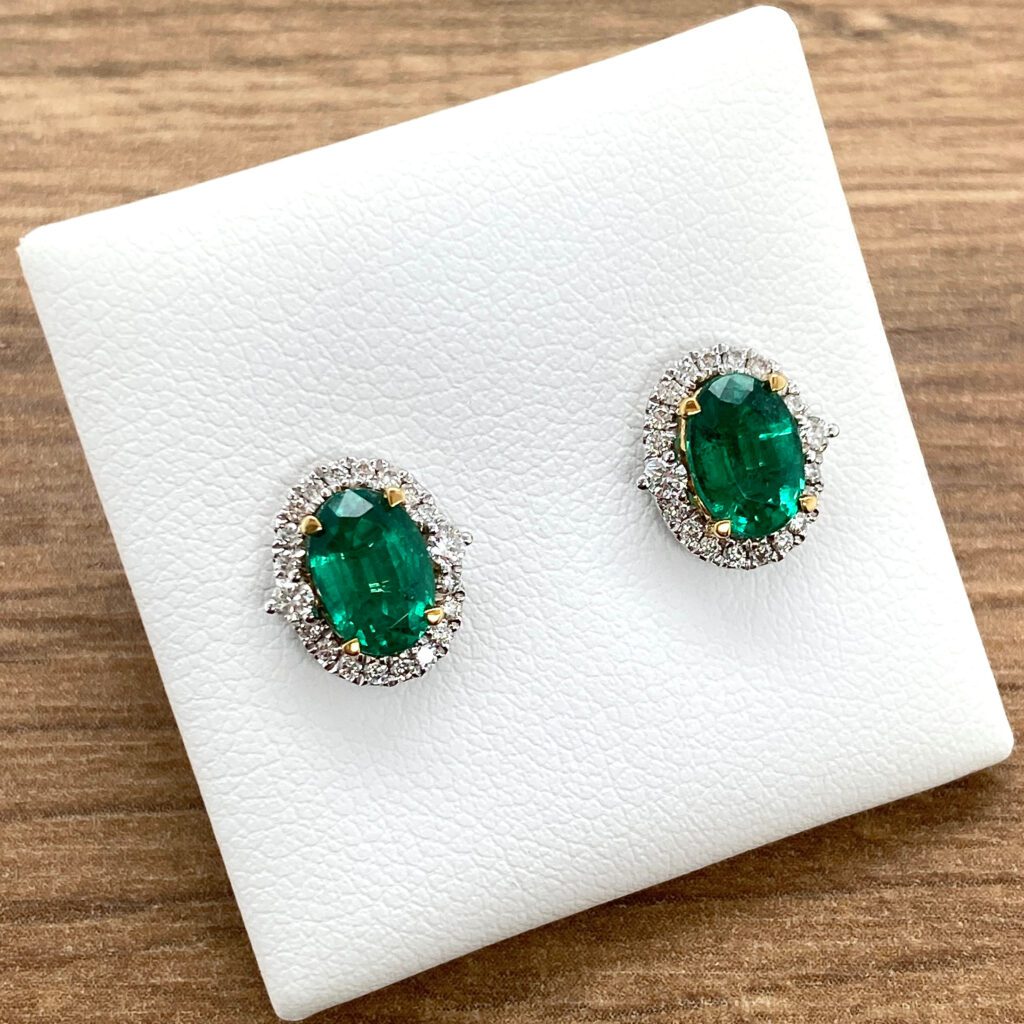 Emerald and diamond halo stud earrings.