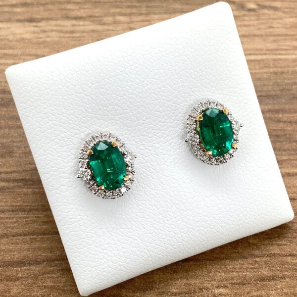 Emerald and diamond halo stud earrings.