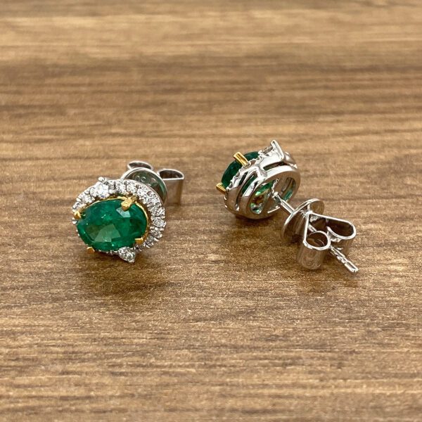 Emerald and diamond halo stud earrings.