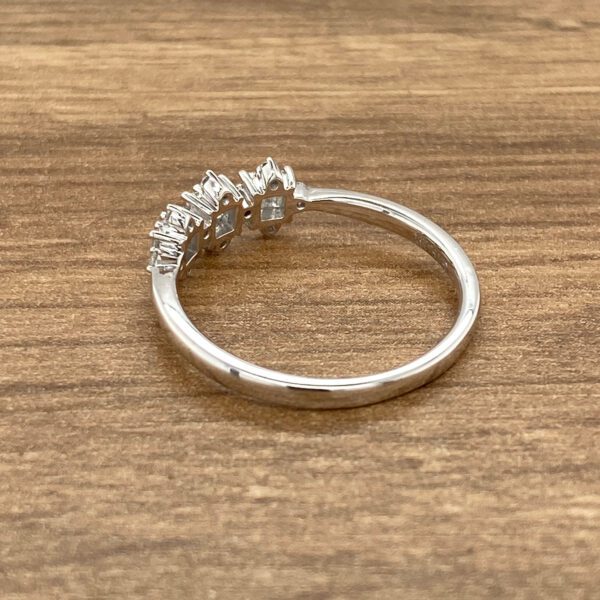 Silver ring with three diamond accents.