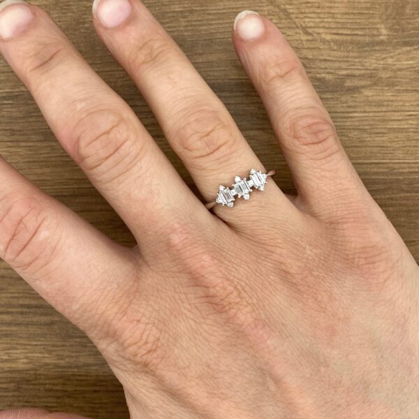 Hand wearing baguette diamond ring.