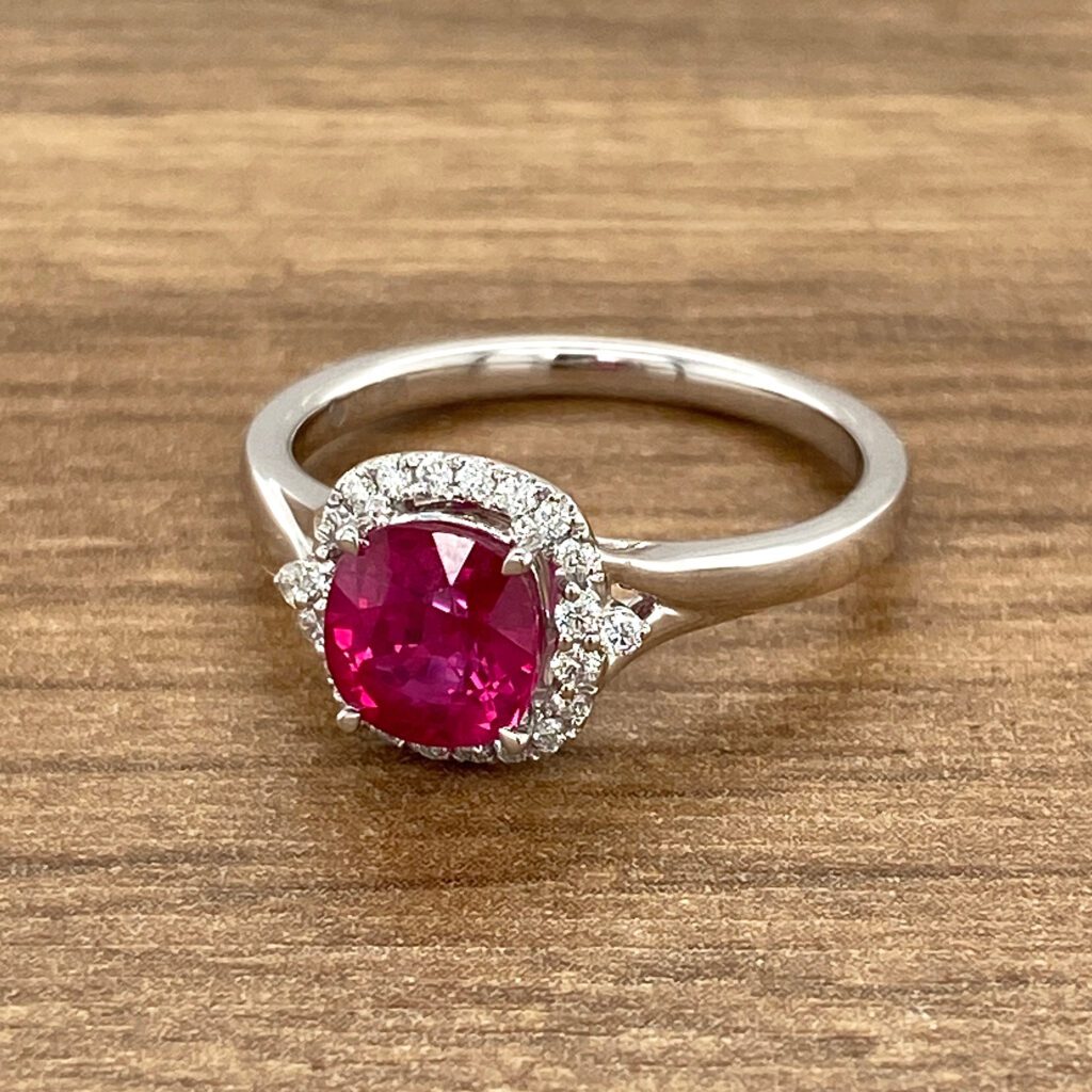 Here's an alt text suggestion: Ruby and diamond halo ring.