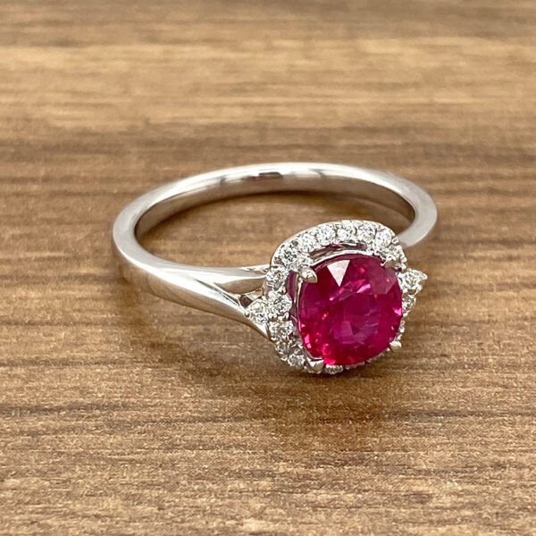 Here's an alt tag for the image: Ruby ring with diamond halo.