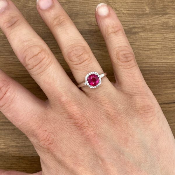 Ruby halo ring on a hand.