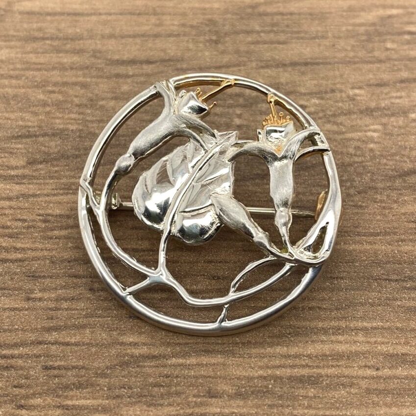 Silver flower brooch, circular design.