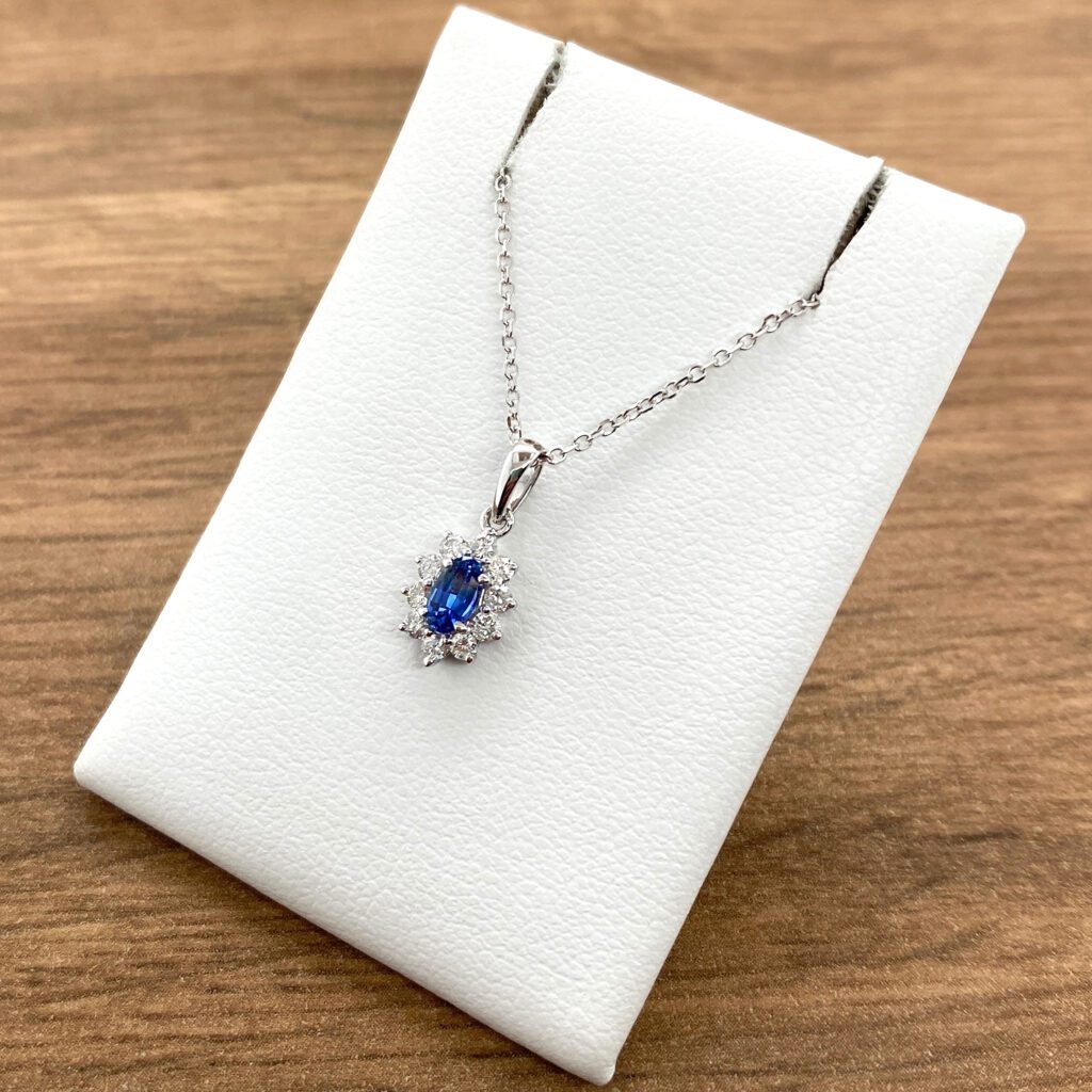 Oval sapphire and diamond pendant necklace.