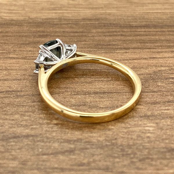 Gold three-stone ring with dark center.