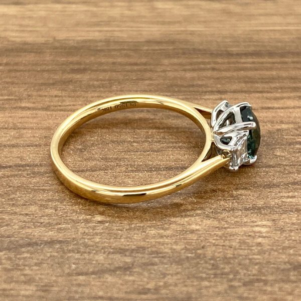 Gold ring with green gemstone and diamonds.