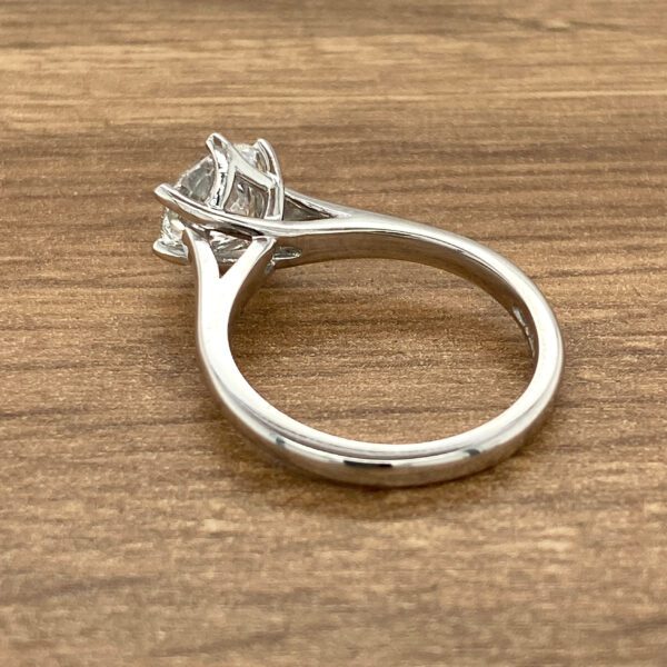 Silver solitaire ring with prongs.