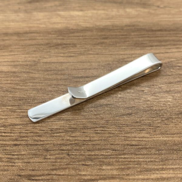 Silver tie bar on wood background.