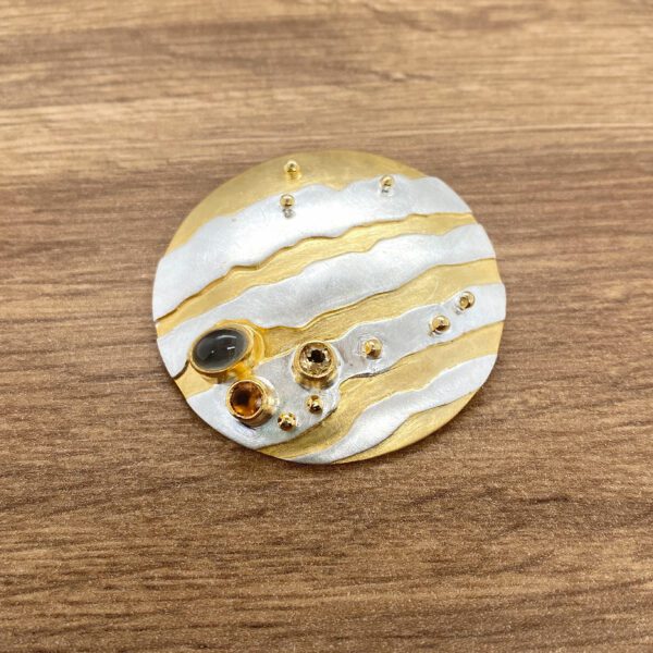 Gold and silver brooch with gemstones.