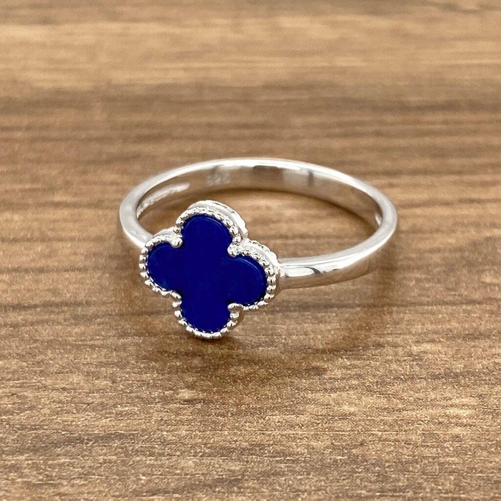 Silver clover ring with blue stone.