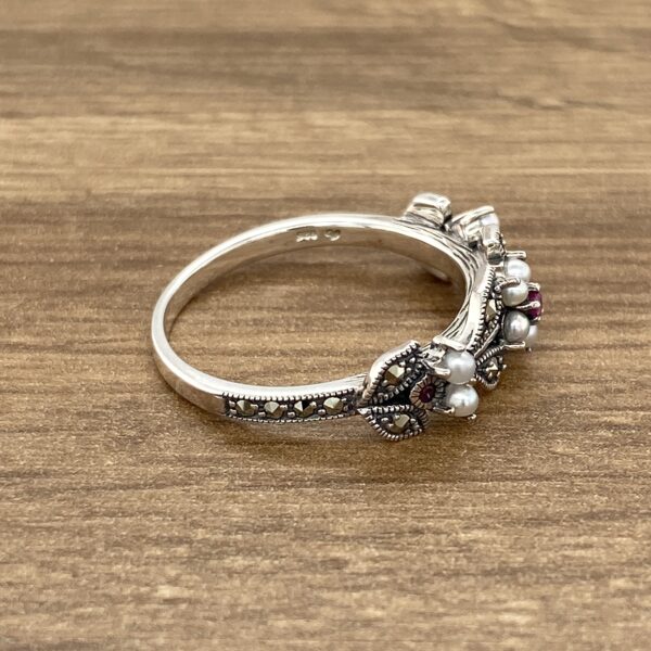 Silver ring with pearls and gemstones.