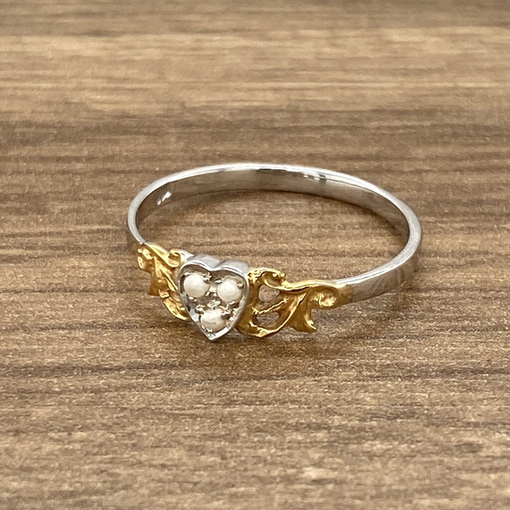 Heart-shaped ring with pearls and gold.