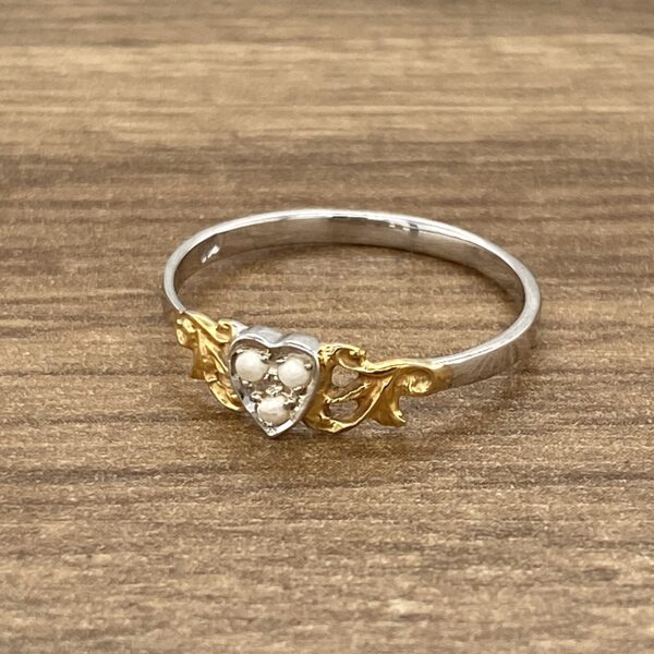 Heart-shaped ring with pearls and gold.