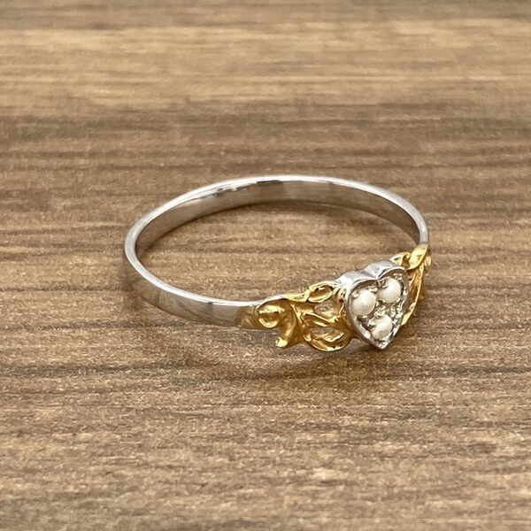 Heart-shaped ring with pearl detail.