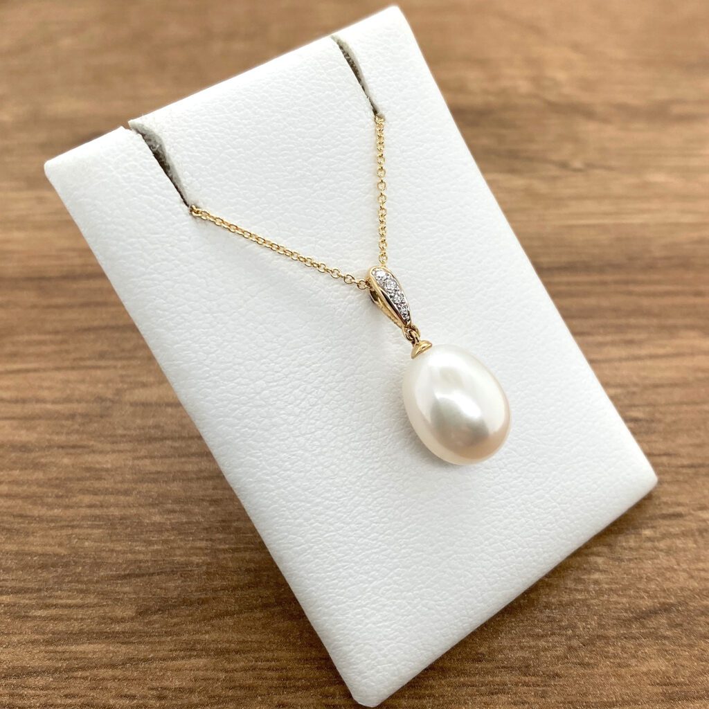 Gold pearl necklace with diamond accents.