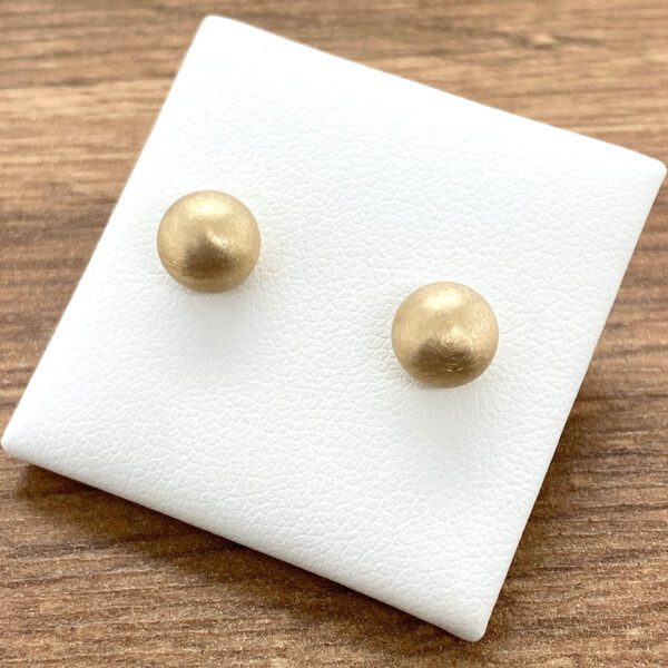 Gold ball stud earrings on display.