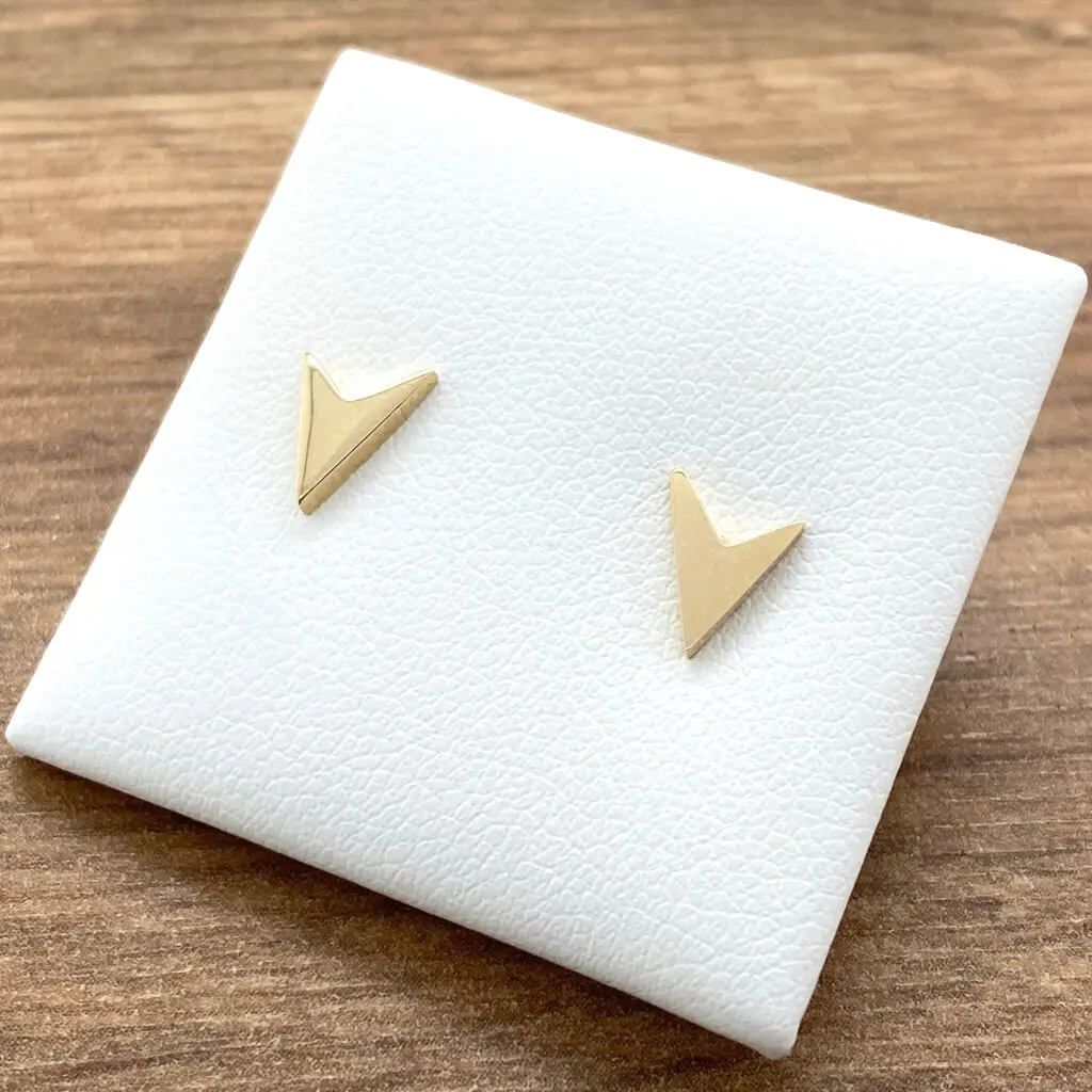 Gold chevron stud earrings on display.