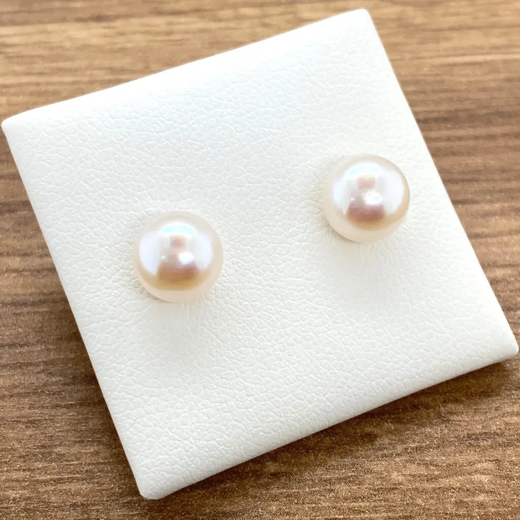 Pair of delicate pearl stud earrings.