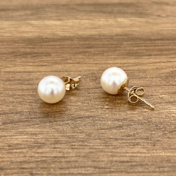Pearl stud earrings, gold setting.