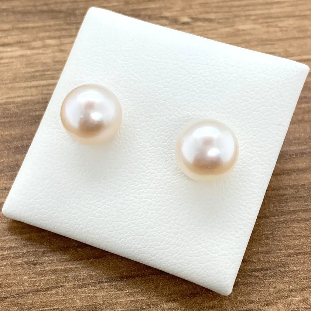 Pair of delicate pearl stud earrings.