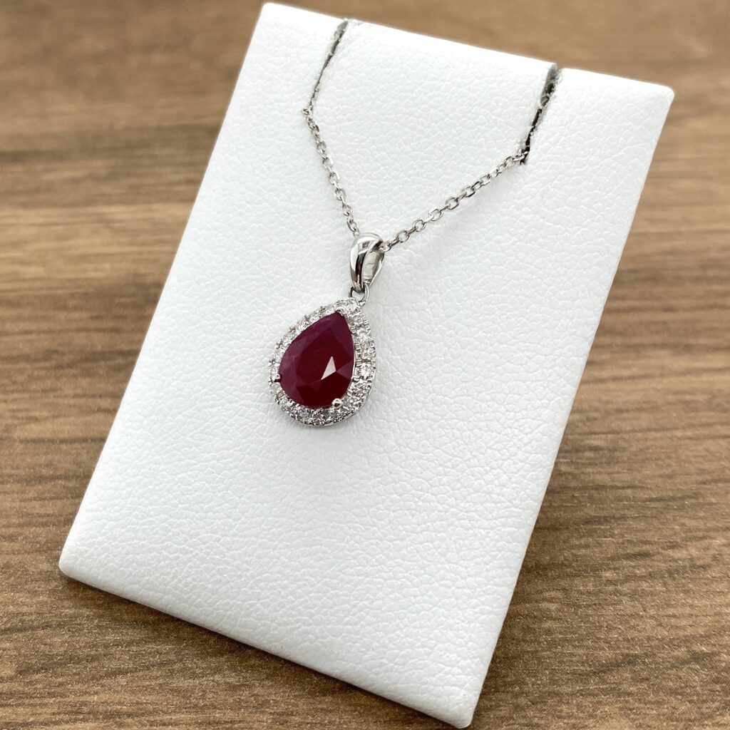 Pear ruby pendant with diamond halo.