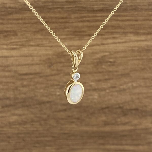 Oval opal and diamond pendant necklace.