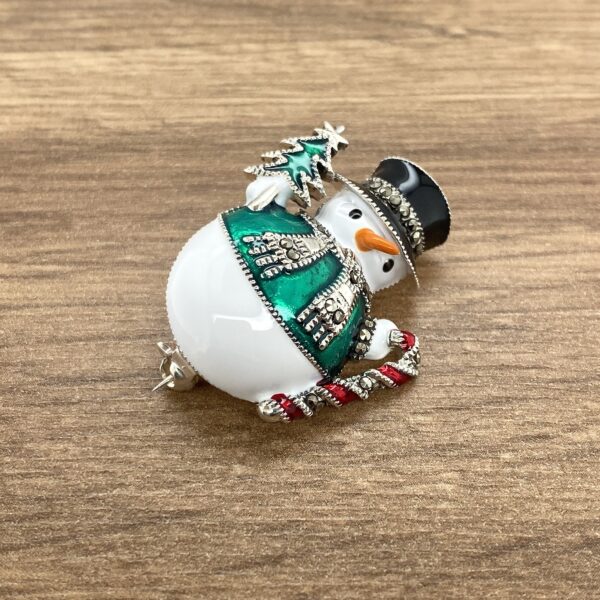 Here's an alt tag for the image: Green-coat snowman Christmas brooch.