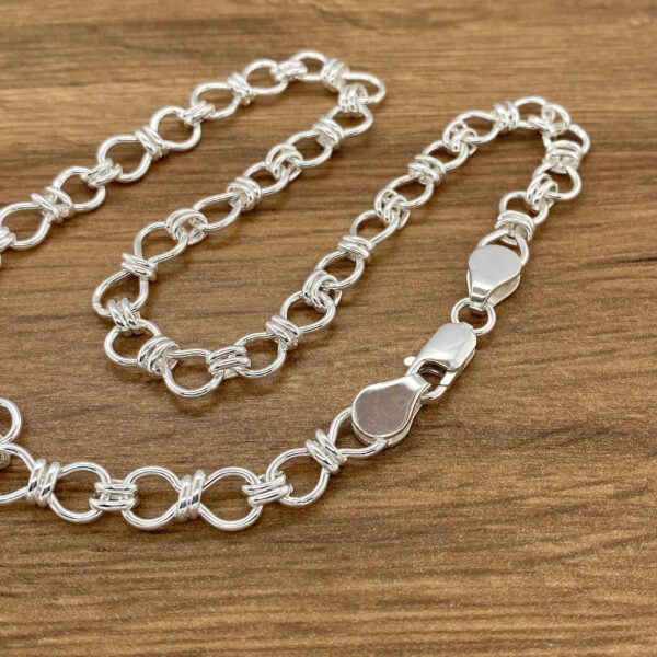 Silver chain link bracelet on wood.