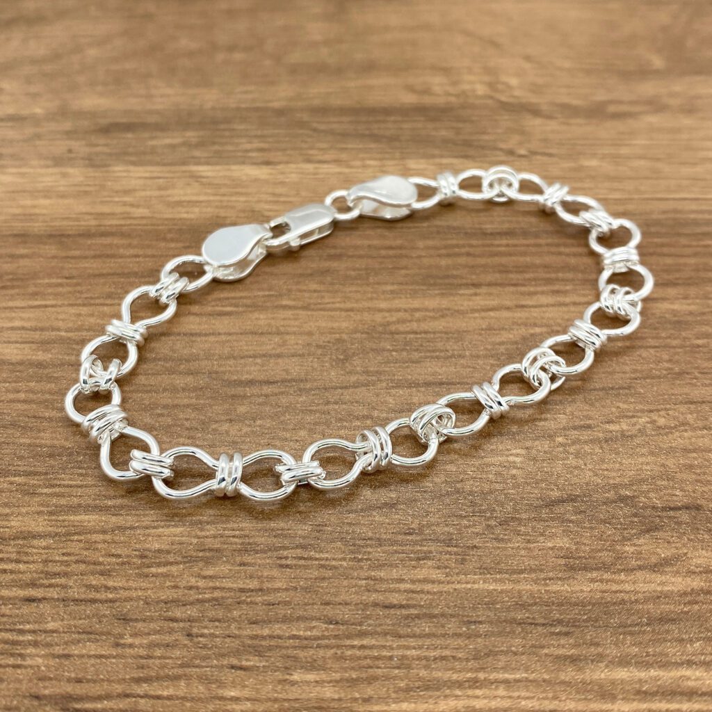 Silver linked bracelet on wood.