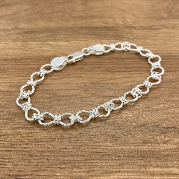Silver linked bracelet on wood.