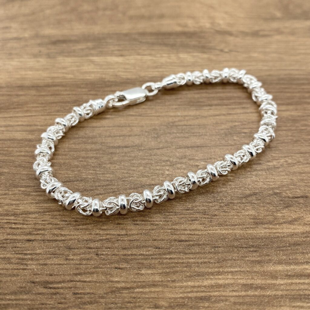 Silver Byzantine bracelet on wood.